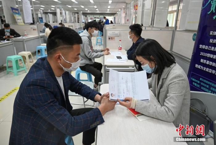 4月14日，招聘者在查看求職者簡(jiǎn)歷。<a target='_blank'  data-cke-saved- >中新社</a>記者 王剛 攝