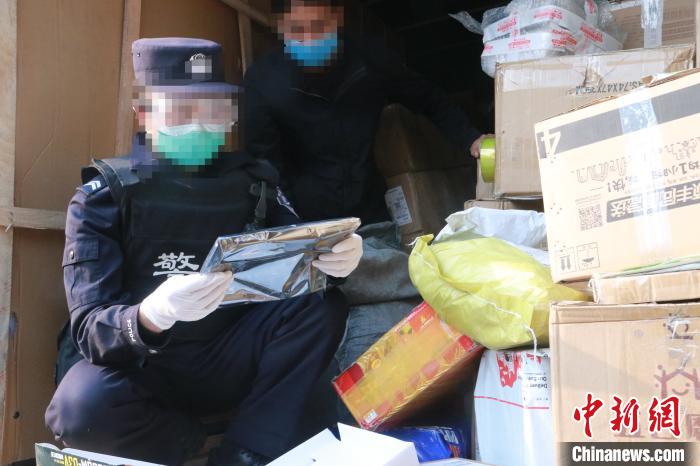 圖為勐康邊檢站民警在對(duì)快遞運(yùn)輸車輛進(jìn)行例行檢查?！钐?攝