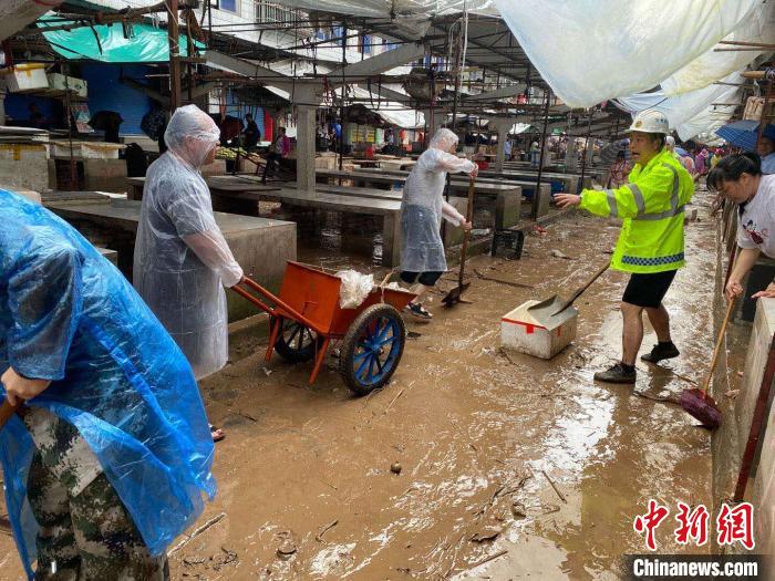 圖為7月26日，暴雨引發(fā)的洪水過境后，重慶萬(wàn)州區(qū)分水鎮(zhèn)政府干部職工及志愿者清掃淤泥和垃圾。　　重慶萬(wàn)州區(qū)委宣傳部供圖 攝